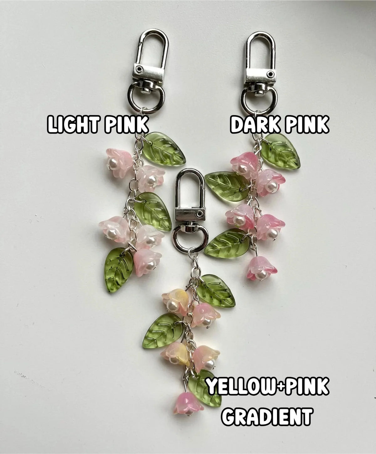 Handmade Lily of the Valley flower keychains in light pink, dark pink, and yellow-pink gradient colors.