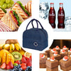 A dark blue insulated canvas lunch bag shown next to various fresh fruits and sandwiches.