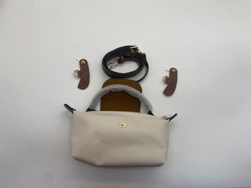 A beige waterproof nylon crossbody bag with a detachable mini pouch and leather straps.