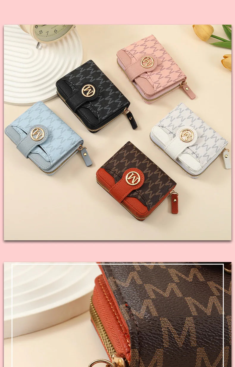 A collection of five compact wallets in various colors and patterns, including pink, black, blue, and beige, displayed on a l