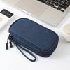 A dark blue portable digital accessory organizer pouch next to a silver electronic device.