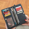 A dark gray retro long wallet with a double zipper and multiple card slots is held in a hand.
