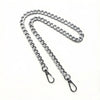 A silver metal chain crossbody strap laid out on a white background.