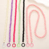 A collection of handmade acrylic bead cross phone charms in various colors including white, purple, pink, green, and black.