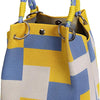 A yellow and blue geometric colorblock knitted bucket bag with woven handles.