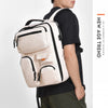 A person is carrying a beige and black large capacity travel backpack.