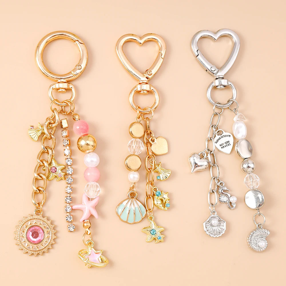 Gold and silver jewelry featuring a seashell starfish charm with pearl accents on a chain.