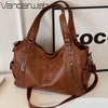 Sac à main en cuir marron à plusieurs poches sur fond blanc.