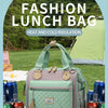 Une sac isotherme vert clair est montré à l'extérieur sur une surface en bois avec des contenants de boissons et de nourritur