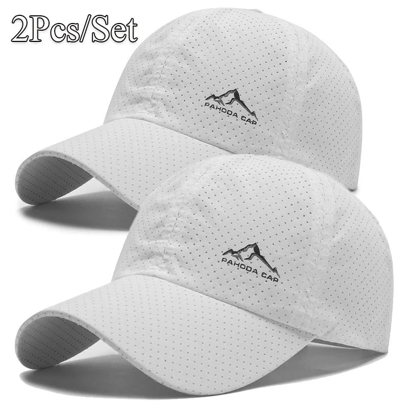 A set of two white outdoor baseball caps featuring a mountain logo embroidered on the front.
