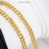 A close-up of a gold-colored, exquisite carved chain strap for bags.