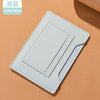 Portefeuille de voyage fin bleu clair pour passeport et documents sur fond beige.