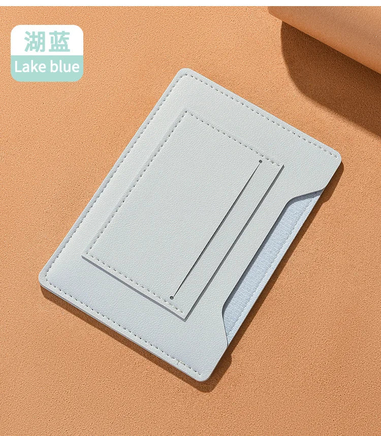 Portefeuille de voyage fin bleu clair pour passeport et documents sur fond beige.