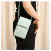 A light mint green luxury women's crossbody shoulder bag is shown being held by a person wearing black clothing.