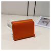 An orange card holder with a zipper closure is displayed on a white surface.