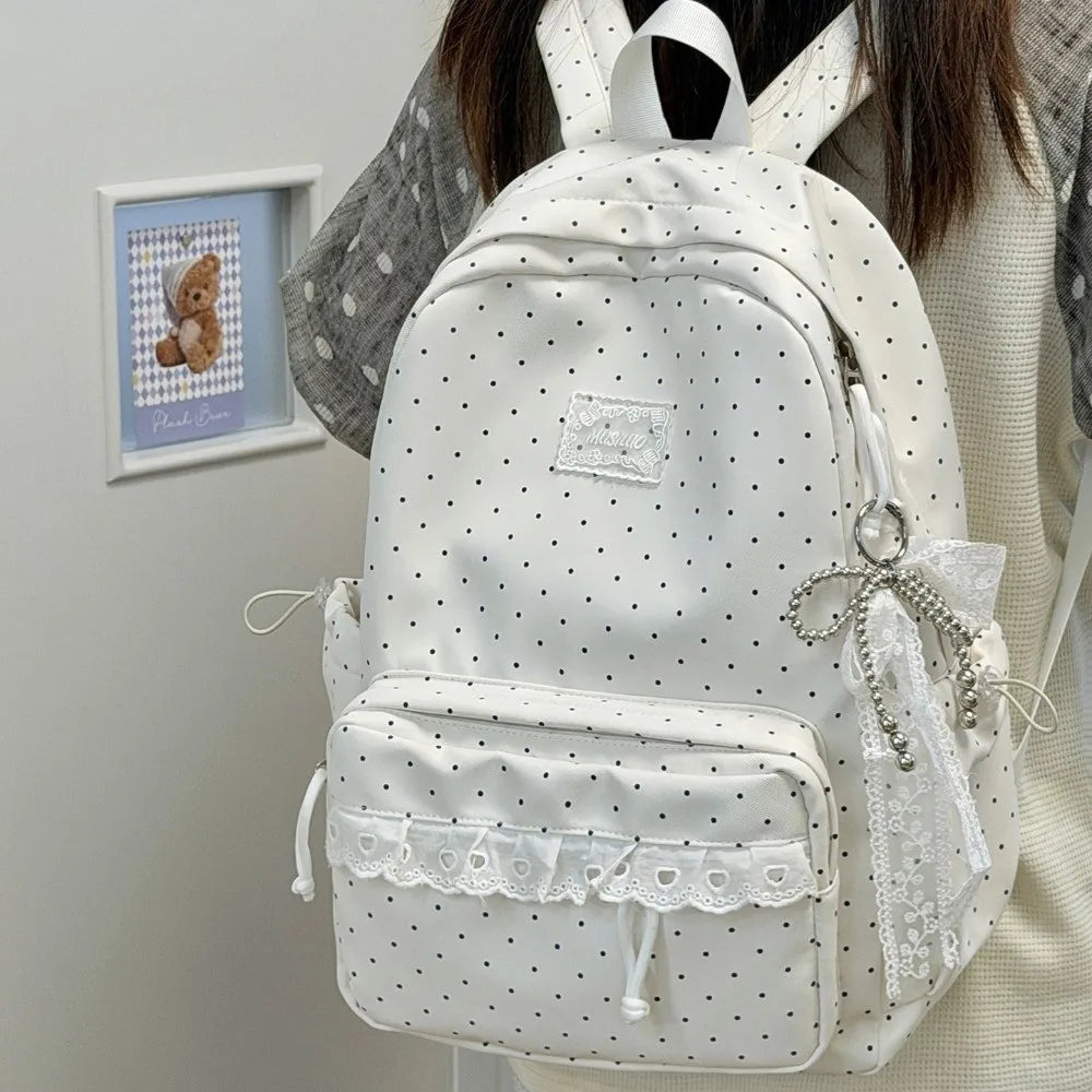 A white polka dot nylon travel backpack with a laptop compartment is shown against a light background.