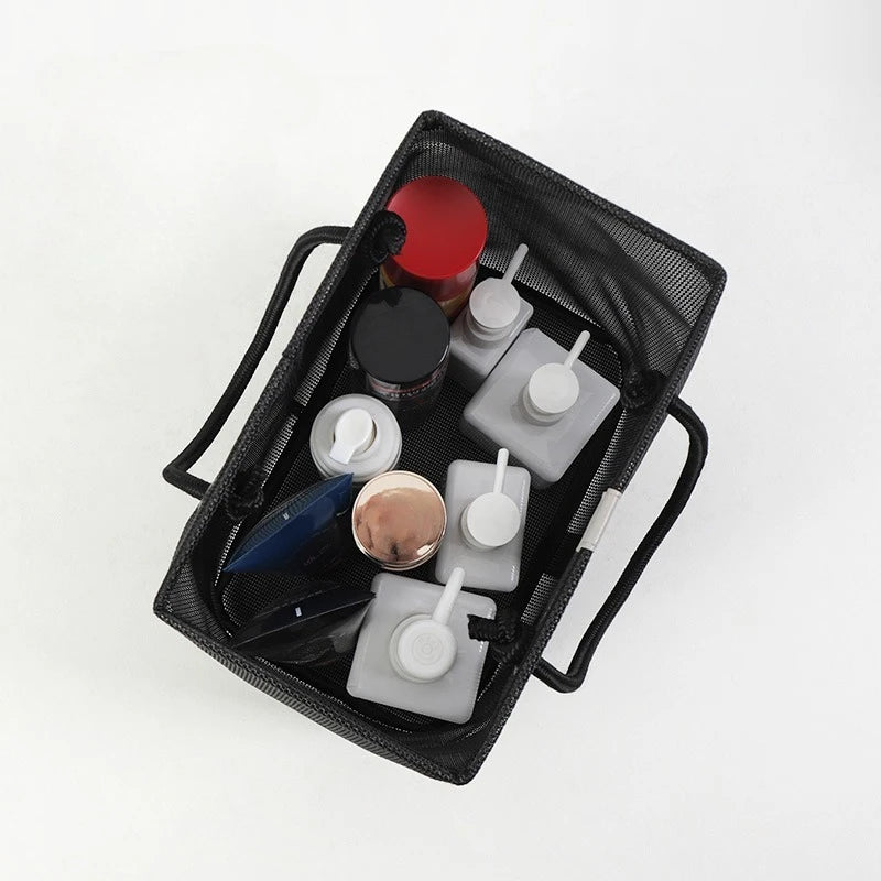 Black mesh drainage shower tote with a handle containing various skincare and grooming products