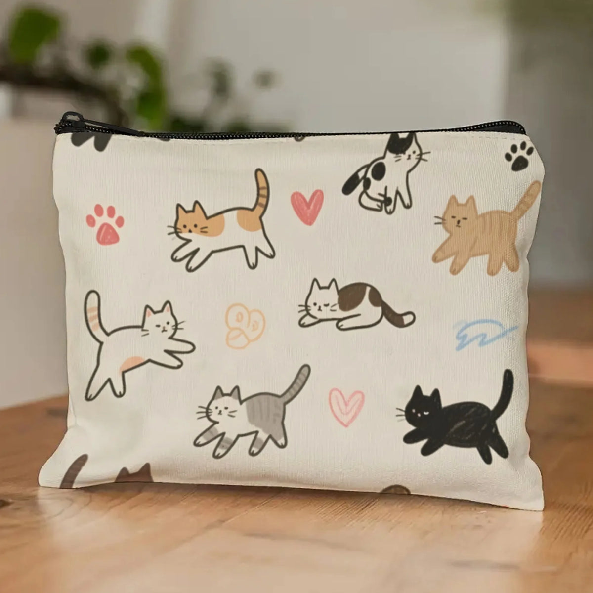 A cream-colored pouch featuring a repeating pattern of simple line drawings of cats in various poses.
