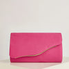 A vibrant pink velvet evening clutch with a visible yellow lining resting on a white surface.