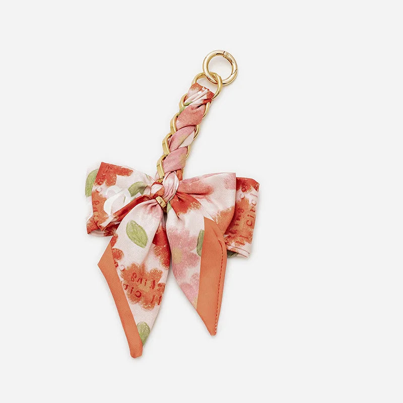 Pink floral patterned adjustable bag strap with a gold ring closure