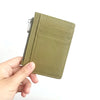 A hand holds a olive green genuine leather zipper card holder and coin purse.