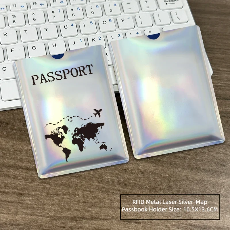 Silver-map passport holder with a world map design placed on a wooden desk next to a laptop keyboard.