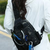 A black tactical fishing gear storage chest bag worn on a person's back, featuring knife and tool slots.