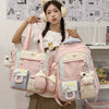 A young woman is holding a pink Kawaii Harajuku backpack with light blue accents and a laptop compartment.