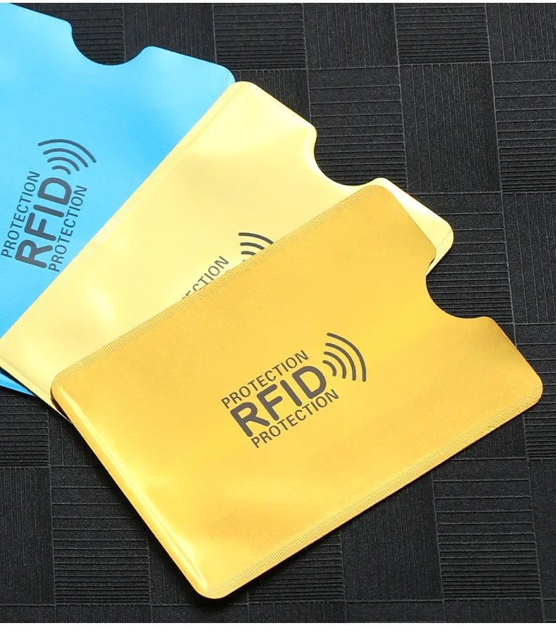 Geliches RFID-Schutz-Wallet-Cover neben einem blauen auf dunkler Oberfläche.