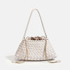 A cream-colored handwoven PU shoulder bag with a woven texture and long leather straps.
