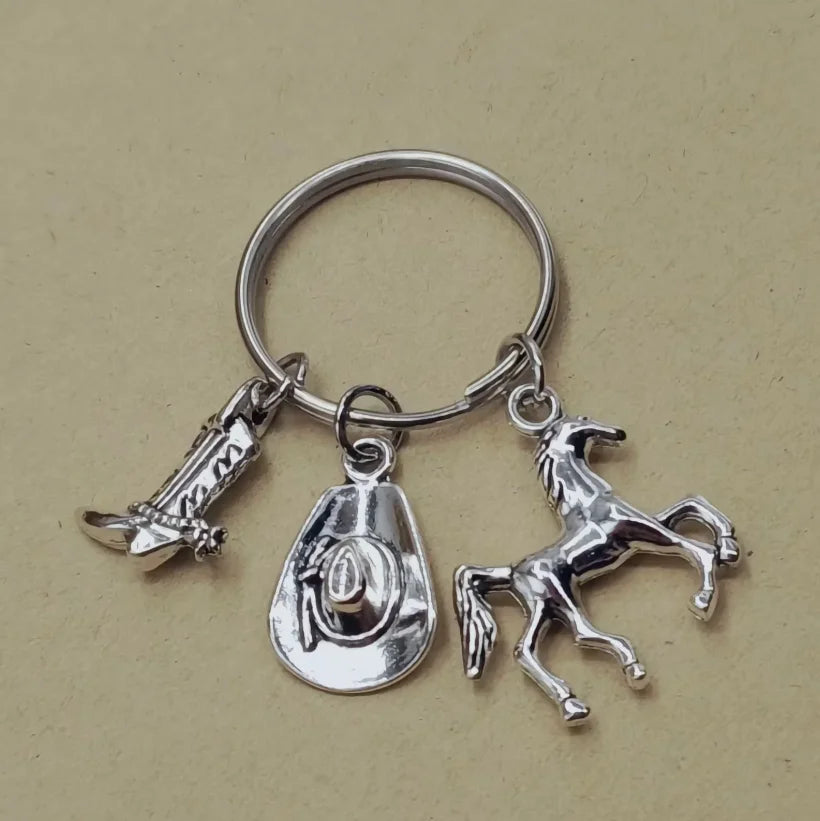 Silver keychain set featuring a cowboy boot, hat, and horse silhouette.