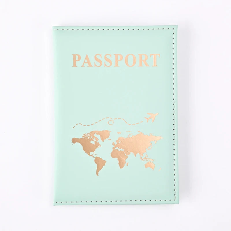 A light mint green passport holder wallet with gold foil printing of a world map and the word PASSPORT.