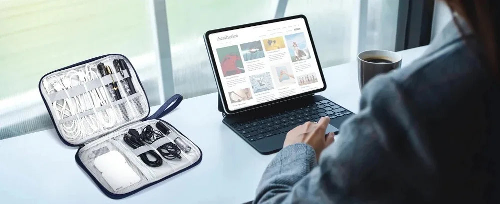 A person is using a laptop to view an application while several travel cable organizers and accessories are displayed on a li