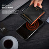 A hand holds a black slim bifold wallet with RFID blocking technology over a smartphone.