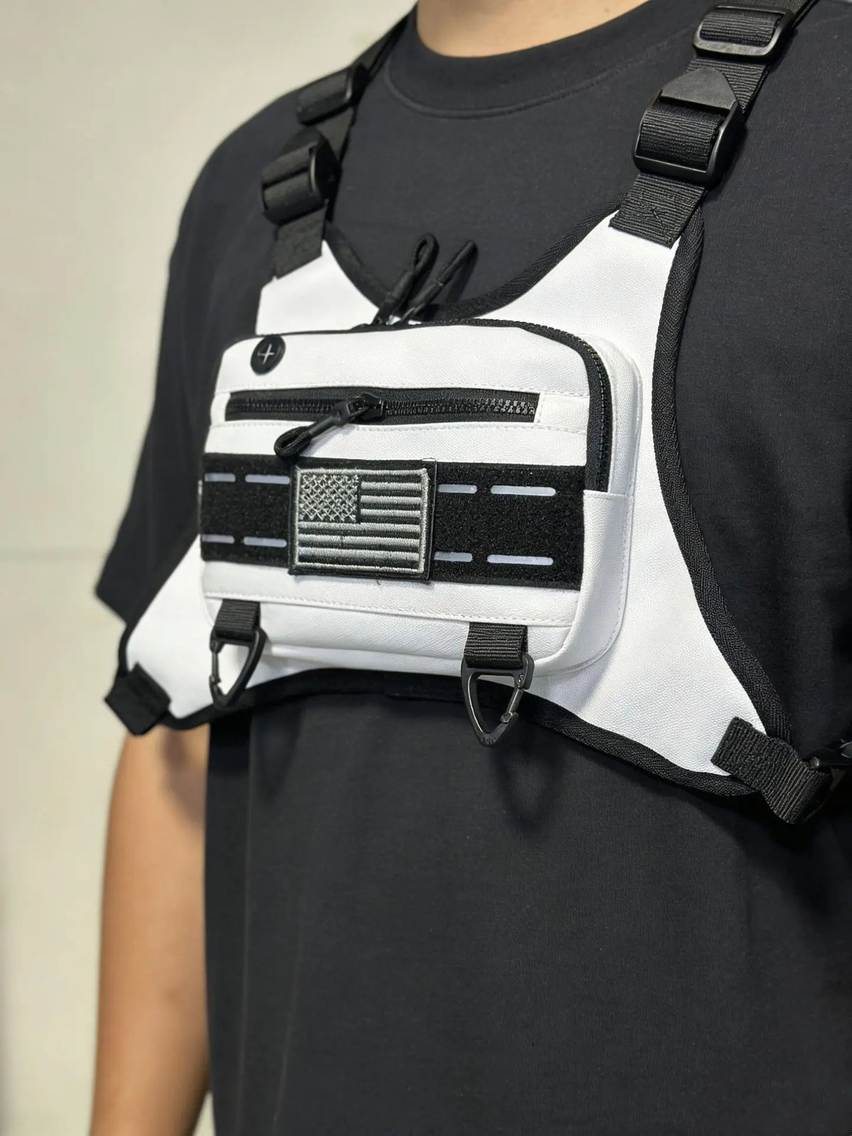 Un t-shirt noir avec un sac à dos blanc et une sangle noire représentant un drapeau américain.