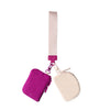 A pink strap attached to a small purple nylon pouch with a light beige flap.