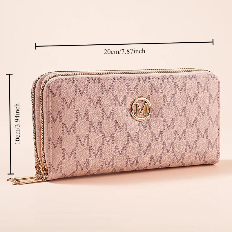 A light pink quilted wallet with gold zipper details and a circular monogram on the front.
