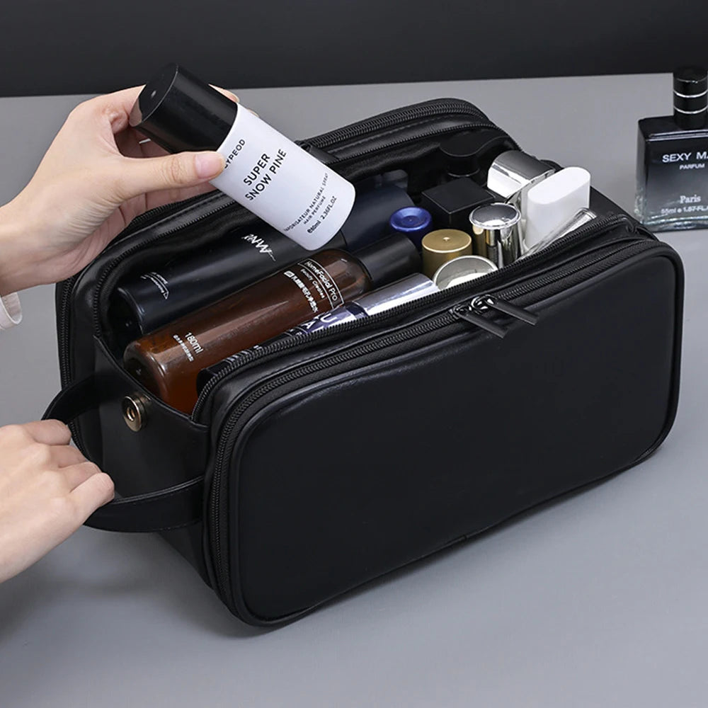 Une main ouvre un sac de toilette en cuir PU noir révélant divers produits de soin.