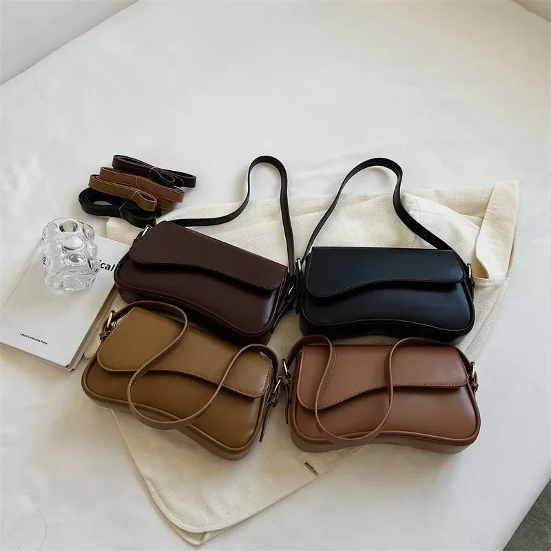 Colección de bolsos cruz estilo vintage de cuero marrón y negro sobre una superficie blanca.
