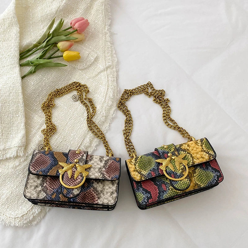 A gold chain elegant retro crossbody bag with a floral pattern resting on a white cloth.