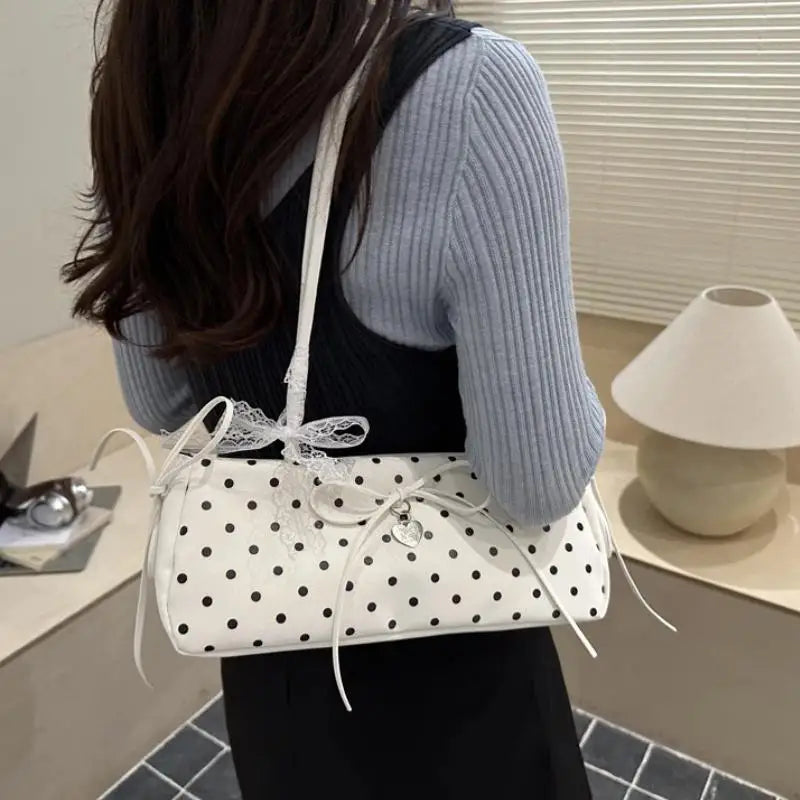 Weiße Schultertasche mit schwarzen Polkadotten und weißen Spitzendetails.
