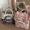 A collection of quilted fabric storage baskets in various floral patterns and colors resting on a wooden floor.
