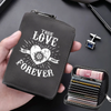 A dark gray compact card wallet with the text True Love Forever embossed on it, shown being held next to a stack of credit ca
