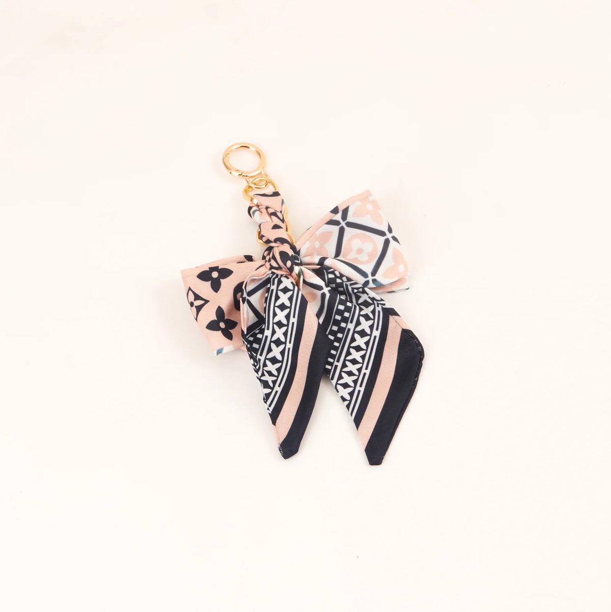 Lazo de seda estampado rosa y negro atado con un anillo de llavero de color dorado.