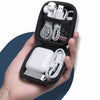 Una mano sostiene un estuche negro abierto para AirPods y accesorios, mostrando auriculares y cables de carga dentro.