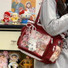 A transparent red shoulder tote bag filled with various small plush toys and accessories.