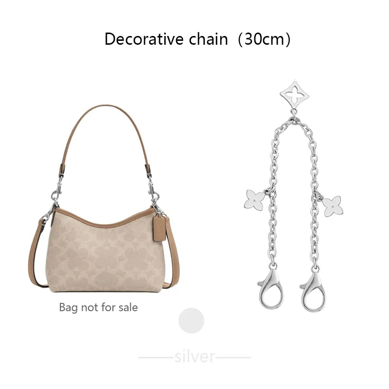 A silver decorative chain with a charm is shown next to a beige leather pouch bag.