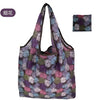 A reusable eco tote shopping bag with a purple and green floral pattern.