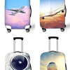 A collection of four luggage bags, including a blue and pink suitcase, a light blue suitcase, a clear acrylic suitcase, and a
