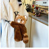 A brown red panda plush toy is displayed against a light-colored t-shirt.